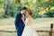 Amazing attractive young couple with closed eyes in wedding day. bride in elegant white long dress and blue bouquet in