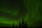 Amazing aurora borealis dancing on star filled autumn night sky over spruce trees
