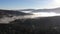 Amazing autumn landscape in Carpathian Mountains. Morning fog over valley, coniferous forests on the slopes