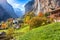 Amazing autumn landscape of touristic alpine village Lauterbrunnen with famous church and Staubbach waterfall