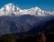 Amazing autumn panorama with mountains covered with snow and forest against the background of blue sky and clouds. Mount Everest,