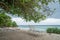 Amazing beach landscape during rainy season time with trees, sunbed and ocean at the tropical island