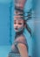 Amazing beautiful art surreal portrait of young woman in grey dress and beaded scarf underwater