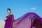 Amazing beautiful brunette woman with the Peacock feather in purple fabric in the desert.