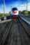Amazing beautiful impressive front view on moving white red blue beautiful high speed passenger train in motion blur. High speed