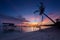 Amazing beautiful sunset with silhouette wooden jetty and coconut tree