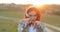 amazing beautiful young redhead lady, with freckles on his face, standing on sunset in background, chatting by mobile