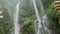 Amazing big waterfall in jungles. Traveller show it with hands. Asian nature.