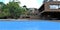 Amazing blue swimming pool in the yard of a new newly built natural red brick house in the old quarter of Bangkok. 3d rendering