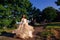 Amazing bride whirls her beige dress while standing on the path