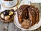 Amazing Chocolate Easter Cake with chocolate drops and dry cherries on an old wooden background with black and golden eggs. Slice