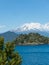 The amazing Choshuenco Volcano surrounded by clouds, over the waters of Lake Panguipulli, in southern Chile
