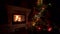 Amazing Christmas tree blinking colorful lights garland near fireplace with burning fire log