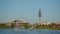 Amazing Christmas tree on long bare tree trunk towers over pictorial city park with lake, fountain, trees and walking people