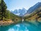 Amazing clear mountain lake in forest among fir trees in sunshine. Bright scenery with beautiful turquoise lake against the