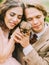 Amazing composition of the newlyweds holding and petting the lovely brown ferret. Close-up photo.