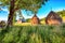 Amazing countryside landscape of romanian village Rogojel with forested hills and haystacks on a grassy rural field in mountains