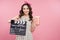 Amazing cute young pretty girl holding clapper board and smiling