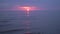 Amazing dark scenic vivid crimson rare red sunset with violet and magenta colors at the Baltic Sea with small sun at the