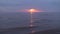 Amazing dark scenic vivid crimson rare red sunset with violet and magenta colors at the Baltic Sea with small sun at the