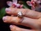 a amazing delicate flowers a woman wears a ring on her finger.Generative AI