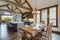 Amazing dining room near modern and rustic luxury kitchen with vaulted ceiling and wooden beams, long island with white quarts