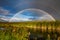 Amazing double rainbow over the small river.