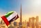 Amazing Dubai skyline cityscape with modern skyscrapers and UAE flag. Downtown of Dubai at sunny day, United Arab Emirates