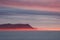 Amazing evening landscape of the coast of the Arctic Ocean with mountains, red fog and clouds at sunset