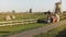 Amazing family sit together in a windmill farm. Dad, mom and kids enjoy wonderful bonding time together outdoors. 4K.