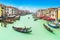 Amazing famous panoramic view from Rialto Bridge at Grand Canal with many gondolas, vaporetto, boats, moorings and historical