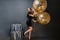 Amazing fashionable young woman on heels, in black luxury dress with big balloons full with golden tinsels on black