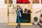 Amazing fashionable young woman in long green coat walking on street on winter holidays time. Cut brunette hair, white