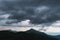 Amazing flowing rainy clouds in evening mountains