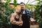 Amazing gardeners posing in the nature greenhouse garden looking aside