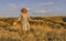 Amazing girl in a hat at sunset in the steppe on the sea