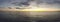 Amazing golden hour sunset panorama with the sky streaked with clouds