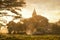 Amazing golden sunset with sunbeams over fields and ancient arch