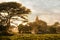 Amazing golden sunset with sunbeams over fields and ancient arch