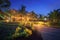 Amazing hotel with lighted paths in flowers garden in summer night