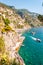 Amazing Italian Positano cityscape on rocky landscape, people on the beach, boats are coming and going to the sea tours,