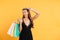 Amazing lady in black dress winking and holding shopping bags.