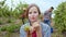 Amazing lady with a perfect smile eating yummy organic grapes from the vineyard while other seasonal workers collecting