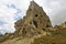 The amazing landscape of Cappadocia. Against the background of the sky rises a bizarre rock with a sharp top.