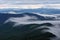 Amazing landscape with high mountains, fog and sky. The early morning mist. Majestic spring day. Dense fog with beautiful light.