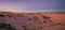 Amazing landscape at sunset, with dunes in the middle of the desert with shades in the sand and green of the little vegetation