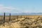 Amazing landscape view golden yellow dried glass hill with fence in autumn with cloud blue sky in south Patagonia, Chile and