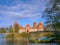 Amazing landscape view of Trakai castle colorful boat and wooden bridge before the gates, Lithuania