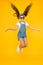 Amazing long hair. Cute small girl with long hair jumping on yellow background. Adorable little child enjoy long