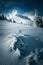 Amazing majestic scenery of a sharp mountain peak with clouds on the blue sky and trees in the foreground